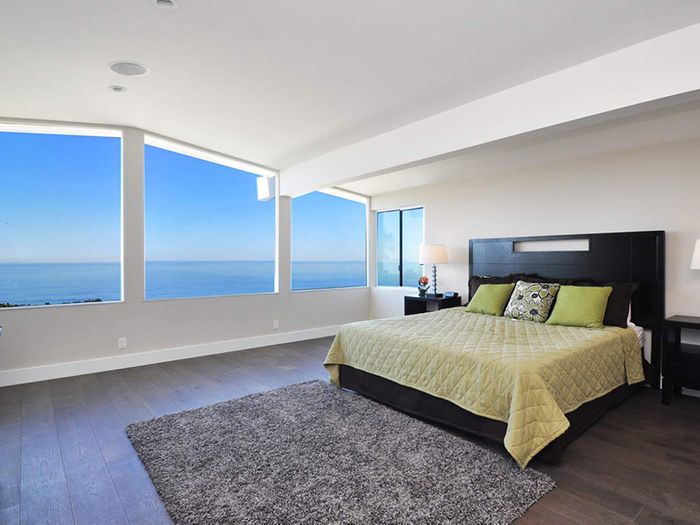 A white accent bedroom and black bed with an ocean view made by general contractor in Walnut Creek, CA